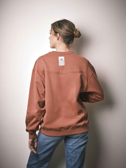 Sweatshirt Crossbeams porté, style western, couleur terracotta. Designé à Paris et fabriqué au Portugal avec finitions haut de gamme.